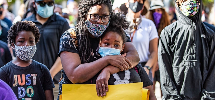 Allison Bracy of Fontana hugs her daughter Brielle Bracy, 10, while attending a rally with hundreds of demonstrators to protest the death of George Floyd during the coronavirus pandemic in Riverside, California, June 4, 2020. 