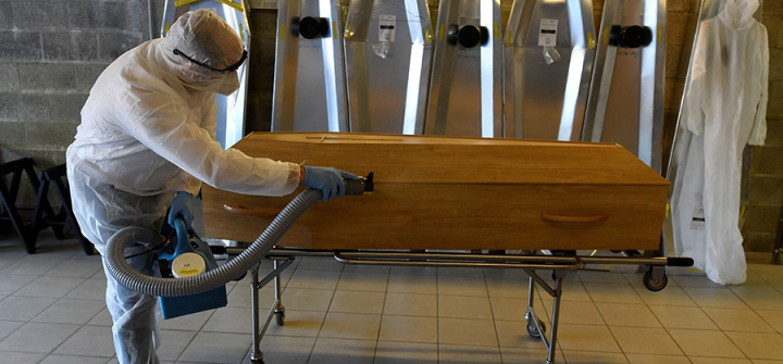 A Chaudoir funeral home employee disinfects the coffin of a COVID-19 victim in Namur, Belgium on April 20, 2020. Image: John Thys/AFP via Getty Images