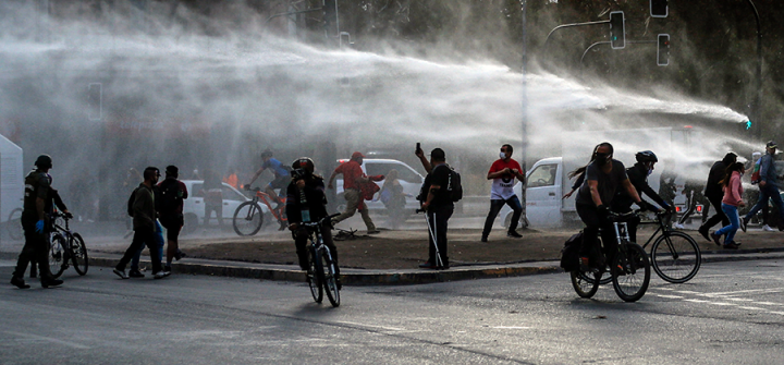 Demonstrators, wearing face masks due to COVID-19, clash with riot police during a protest against President Sebastian Pinera's government in Santiago, Chile on April 27, 2020. 