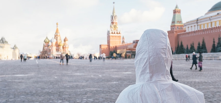 Person in PPE looks out over Red Square, Moscow. Shutterstock