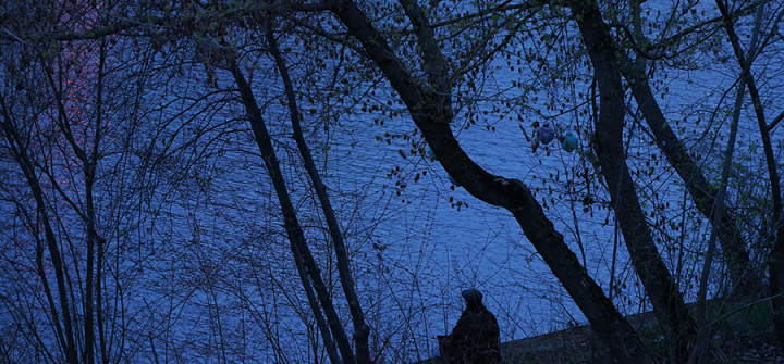 A man sits alone beside the Spree River during a lockdown in Berlin on April 16, 2021. Image: Sean Gallup/Getty Images