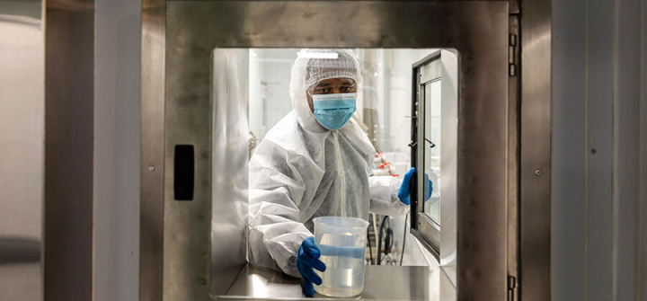 A technician places a beaker into a hatch inside the Afrigen Biologics & Vaccines Ltd. laboratory facility in Cape Town, South Africa, July 12, 2021; the WHO announced it will establish its first-ever mRNA technology transfer hub in Cape Town in an agreement with Afrigen and the Biovac Institute. Photographer: Image: Dwayne Senior/Bloomberg via Getty Images