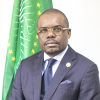 Headshot of Jean Kaseya, MD, in front of an African Union flag.