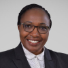 Headshot of Zipporah Gathuya, wearing glasses and a black suit jacket.