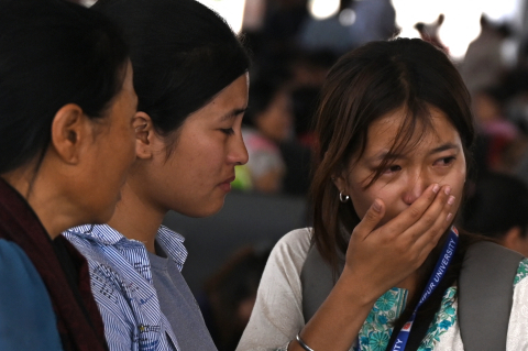 A woman cries as she waits at the Imphal airport to flee ethnic violence in the northeastern Indian state of Manipur on May 7, 2023. 