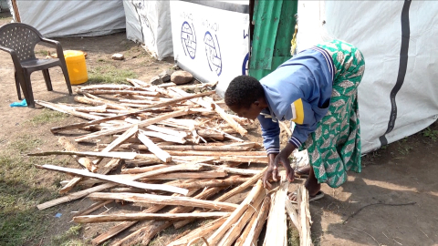 Hellen Anyango sorting a stash of firewood, which she occasionally sells to help support her four children. Nduru camp, Kisumu City, Kenya.