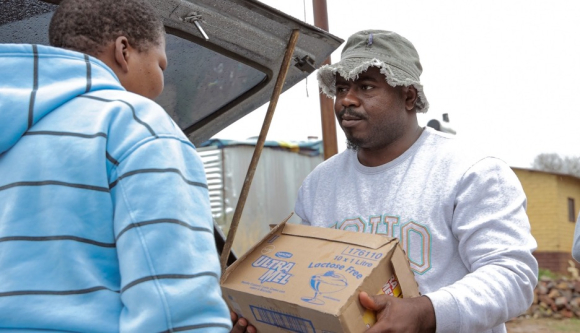 Person carrying boxes of food.