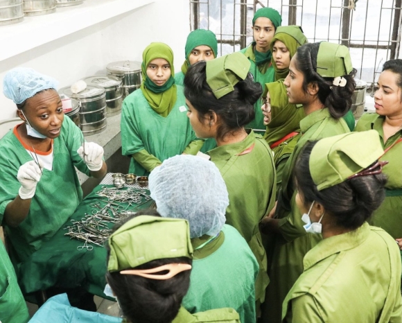 Belinda, clad in green scrubs, takes nursing students dressed in green uniforms through a training session during a surgical mission in Bangladesh .