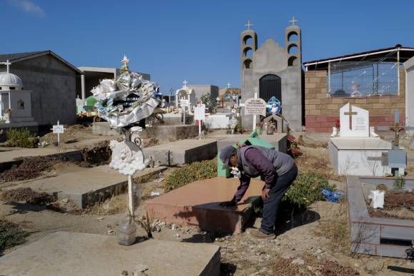 Aron Villanueva tends to the grave of his grandson Axel Villanueva who died of Rocky Mountain Spotted Fever, in Ejido Padre Kino, Mexico. 