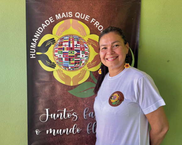 Mayra Figueiras poses with the logo she designed for her non-profit, Humanidade Mais que Fronteiras.