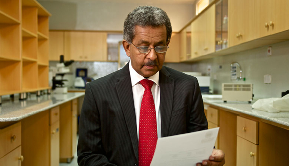 photo of Prof. Fahal reading a paper in a lab