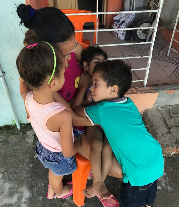 Jorge takes a pause from playing with his cousins to hug Valentina, as Dhulha’s niece softly pleas with an aunt to let her hold Valentina in her lap.