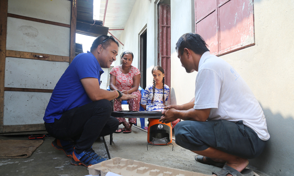 Saraswoti and her family receiving instructions on their new stove.