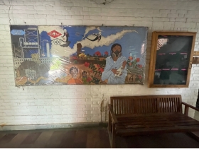Painting of victims of the Bhopal gas leak disaster hanging on the white brick wall of the Sambhavna Clinic.